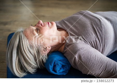 Senior woman relaxing during physiotherapy exercise lying on yoga mat. Senior woman relaxing during physiotherapy exercise lying on yoga mat. 138012273