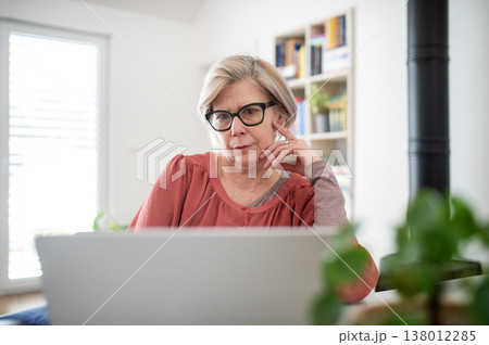 Senior woman working on laptop at home office during retirement. 138012285