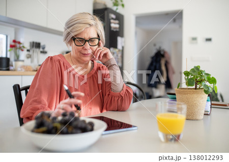 Senior woman working on tablet at home office during retirement. 138012293