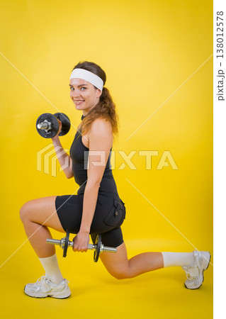 Young woman performing fitness workout lifting dumbbells Young woman performing fitness workout lifting dumbbells 138012578