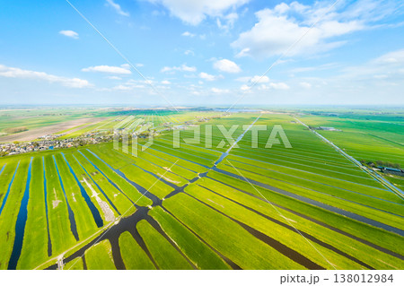 Dutch agricultural landscape with green fields, meadows and water canals under blue sky. Dutch agricultural landscape with green fields, meadows and water canals under blue sky. 138012984