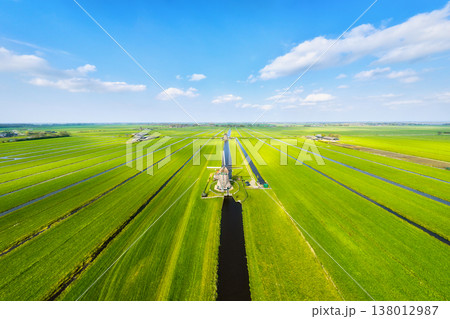 Aerial view of traditional Dutch windmills by water canals in a green field. Aerial view of traditional Dutch windmills by water canals in a green field. 138012987