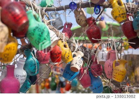 Colorful clay pots with handwritten names hanging on a tree in Turkey 138013002