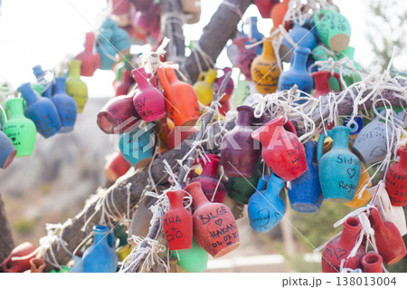Colorful clay pots with handwritten names hanging on a tree in Turkey 138013004
