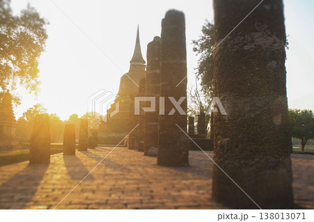 Ancient stone columns and stupa at sunset in Sukhothai Historical Park Ancient stone columns and stupa at sunset in Sukhothai Historical Park 138013071