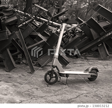 A scooter against the backdrop of iron anti-tank hedgehogs A scooter against the backdrop of iron anti-tank hedgehogs 138013212