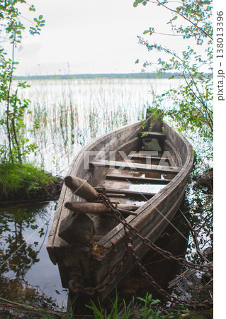 Old wooden rowing boat moored at a lake shore in Ukraine Old wooden rowing boat moored at a lake shore in Ukraine 138013396