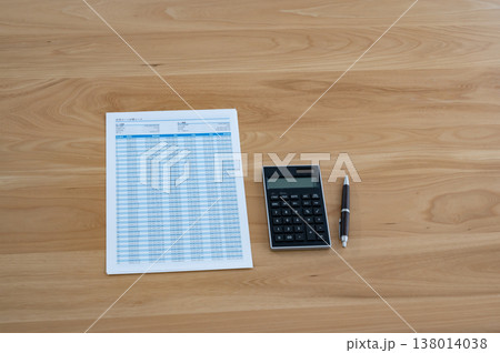 机の上のローン計算シートと電卓とペン 138014038