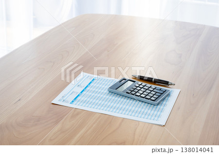机の上のローン計算シートと電卓とペン 138014041
