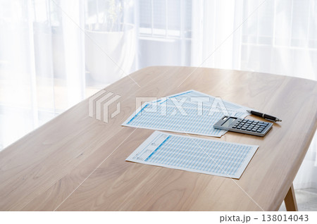 机の上のローン計算シートと電卓とペン 138014043