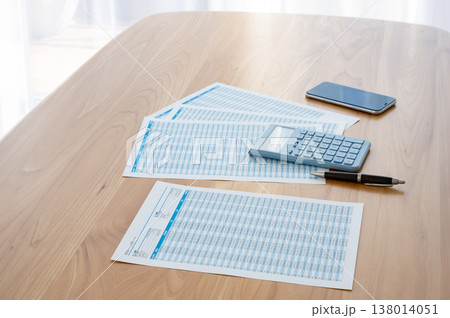 机の上のローン計算シートと電卓とスマホ 138014051