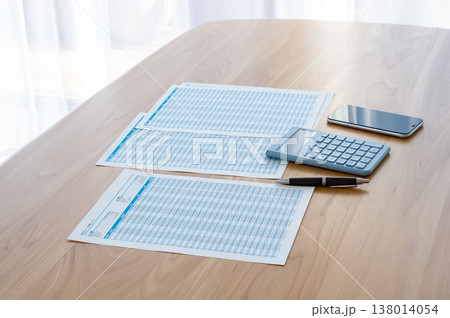 机の上のローン計算シートと電卓とスマホ 138014054