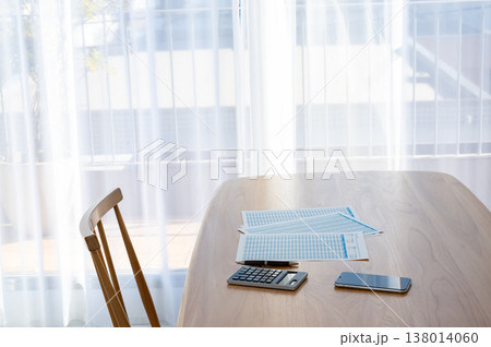 机の上のローン計算シートと電卓とスマホ 138014060