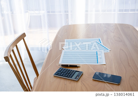 机の上のローン計算シートと電卓とスマホ 138014061
