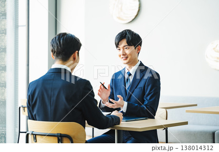 商談で身振り手振り説明をする若いビジネスマン 商談で身振り手振り説明をする若いビジネスマン 138014312