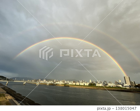 川と街並みの上にかかるダブルレインボーの風景 138015047