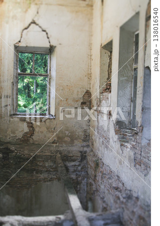 Empty interior of a ruined building with cracked brick walls and old wooden floor beams Empty interior of a ruined building with cracked brick walls and old wooden floor beams 138016540
