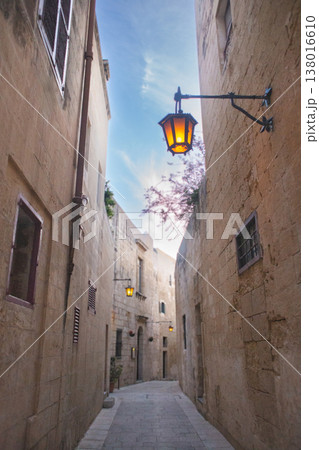 Atmospheric narrow street in Mdina with glowing traditional iron lanterns Atmospheric narrow street in Mdina with glowing traditional iron lanterns 138016610