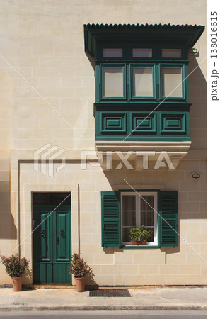 Maltese facade with traditional green wooden balcony and shutters 138016615