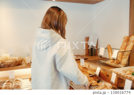 ベーカリーでパンを選ぶ20代女性の後ろ姿 138016774