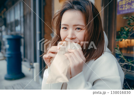観光地で焼きたてパンを食べ歩きする20代女性 観光地で焼きたてパンを食べ歩きする20代女性 138016830