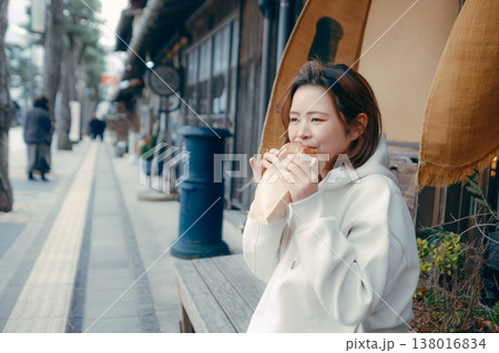 観光地で焼きたてパンを食べ歩きする20代女性 観光地で焼きたてパンを食べ歩きする20代女性 138016834