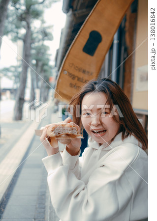 観光地で焼きたてパンを食べ歩きする20代女性 観光地で焼きたてパンを食べ歩きする20代女性 138016842