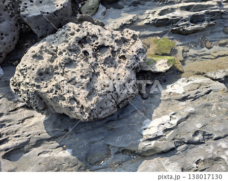 Natural Coastal Rock Formations with Textured and Weathered Boulders by the Shore 138017130