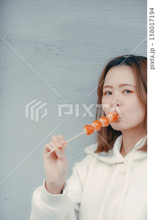 観光地でいちご飴を楽しむ20代女性のポートレート 観光地でいちご飴を楽しむ20代女性のポートレート 138017194