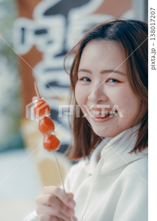 観光地でいちご飴を楽しむ20代女性のポートレート 観光地でいちご飴を楽しむ20代女性のポートレート 138017207