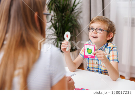 Young boy learning with flashcards at a table with a woman Young boy learning with flashcards at a table with a woman 138017235