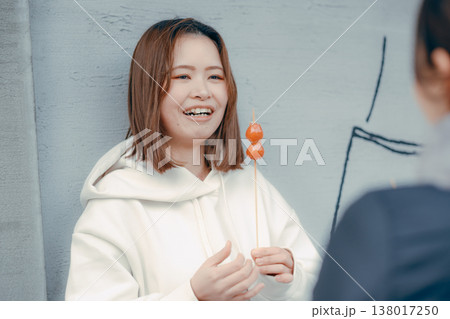 友人と観光地でいちご飴を楽しむ20代女性 138017250