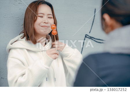 友人と観光地でいちご飴を楽しむ20代女性 友人と観光地でいちご飴を楽しむ20代女性 138017252