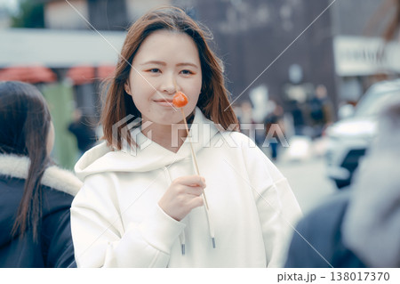 観光地で食べ歩きを楽しむ20代女性の街歩きシーン 観光地で食べ歩きを楽しむ20代女性の街歩きシーン 138017370