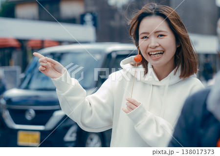 観光地で食べ歩きを楽しむ20代女性の街歩きシーン 観光地で食べ歩きを楽しむ20代女性の街歩きシーン 138017373