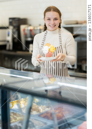 Teenage girl offering delicious ice cream in a coffee shop Teenage girl offering delicious ice cream in a coffee shop 138017571