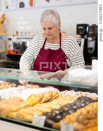 Senior woman salesperson works in cafeteria bakery shop Senior woman salesperson works in cafeteria bakery shop 138017863