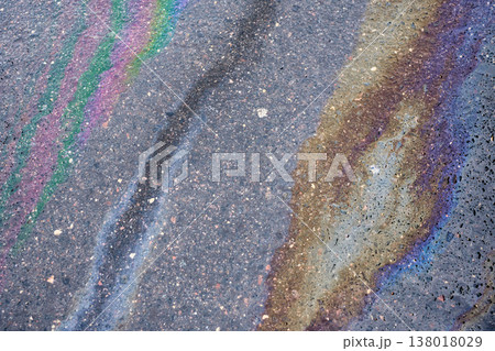 Iridescent oil spill on asphalt road creating a colorful abstract texture and showing environmental pollution Iridescent oil spill on asphalt road creating a colorful abstract texture and showing environmental pollution 138018029