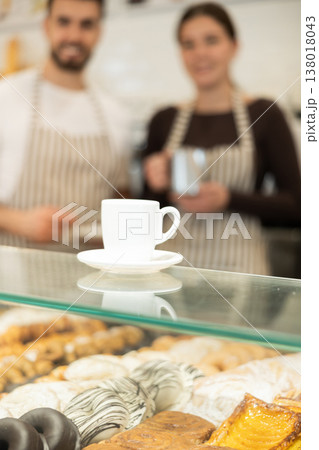 Two cafe employees preparing coffee and delicious pastries 138018043