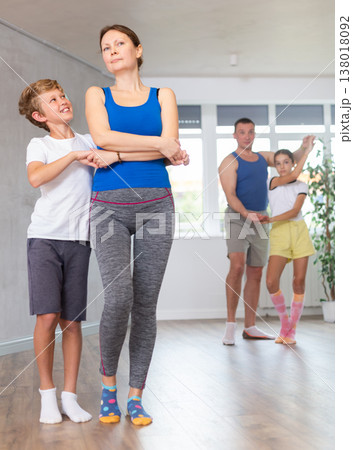 Happy mother and son practicing dance in pairs together with other family members Happy mother and son practicing dance in pairs together with other family members 138018092