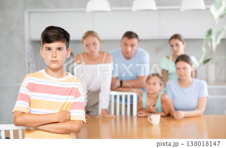 Angry male child turned away from parents and sisters and ignores relatives. 138018147