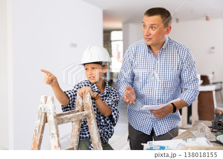 Father and his young son discussing work plan in construction site Father and his young son discussing work plan in construction site 138018155