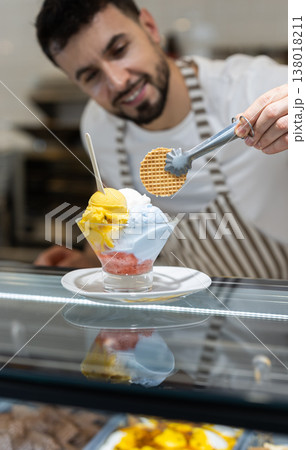 Guy chef or vendor serves ice cream Guy chef or vendor serves ice cream 138018211