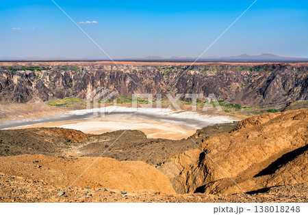 High angle panoramic view showing the white salt crust and steep walls of the Al Wahba volcanic crater located in the desert of Saudi Arabia. High angle panoramic view showing the white salt crust and steep walls of the Al Wahba volcanic crater located in the desert of Saudi Arabia. 138018248