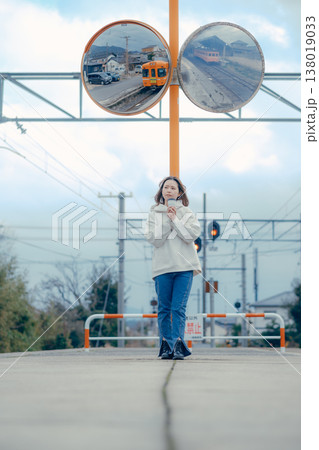 ローカル駅前で佇む20代女性の観光ポートレート 138019033