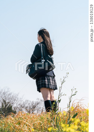 青春のエモーショナルな通学風景。制服姿でスクールバッグを手に、一歩を踏み出す学生の背中（顔無し） 138019129