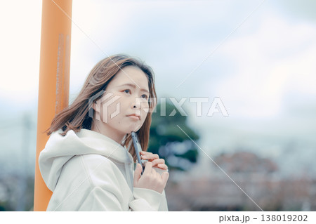 観光地でスマホを見る20代女性の横顔ポートレート 観光地でスマホを見る20代女性の横顔ポートレート 138019202