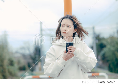 観光地でスマホを確認する20代女性の正面ポートレート 観光地でスマホを確認する20代女性の正面ポートレート 138019237