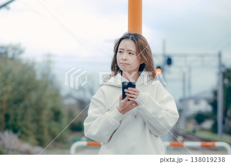 観光地でスマホを確認する20代女性の正面ポートレート 観光地でスマホを確認する20代女性の正面ポートレート 138019238