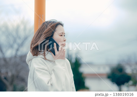 屋外で通話する20代女性の横顔ポートレート 138019316